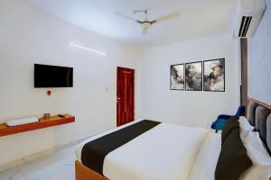 a bedroom with a bed and a tv on the wall at Hotel O A5 Blue in Gorakhpur
