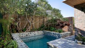 a swimming pool in a garden next to a fence at Villa Capensis in Cape Town