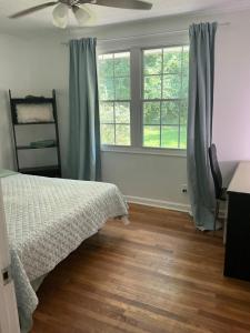 a bedroom with a bed and two windows at Bankston House B&C in Marietta
