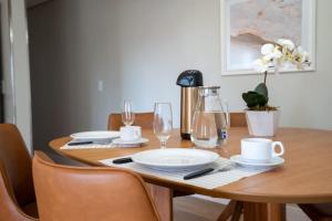 a wooden table with plates and glasses on it at Ap de novela no centro da cidade com garagem in Toledo