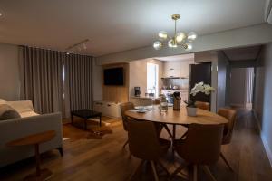 a living room with a dining room table and a kitchen at Ap de novela no centro da cidade com garagem in Toledo