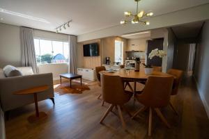 a kitchen and living room with a table and chairs at Ap de novela no centro da cidade com garagem in Toledo