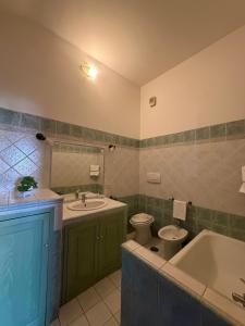 a bathroom with a tub and a toilet and a sink at La Maison D'Amì in Anguillara Sabazia