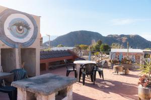 a patio with tables and chairs and an eye on the roof at HOSTEL La Casa de Li - En in Chilecito