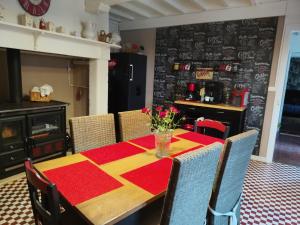 a dining room table with a red and yellow table cloth at Petite maison dans les bois in Villefranque