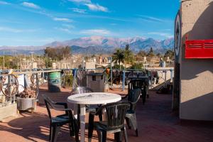 a patio with tables and chairs and mountains in the background at HOSTEL La Casa de Li - En in Chilecito