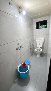 a bathroom with a toilet and a bucket in it at Green Fog Guesthouse in Lonavala