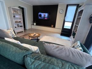 a living room with two green couches and a tv at Ferienwohnung Stoll - modern, mit Ausblick & Grill in Idar-Oberstein