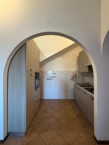 a kitchen with an archway in the middle of a room at La Maison D'Amì in Anguillara Sabazia +10 photos