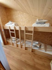 a room with three bunk beds and two chairs at Cabane Bella-Tola in Saint-Luc
