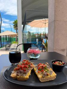 a black plate with toast and a glass of wine at Hotel Camino Del Bosque Centro Pádel in Cholula