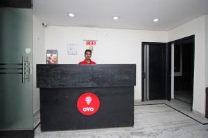 a man standing behind a counter in a room at Hotel O Staysnap in Indirapuram