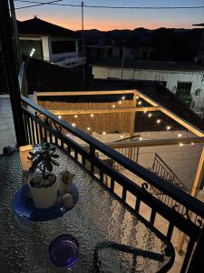 a table with a plant on a balcony with lights at Alfeios cozy stays - Rustic 