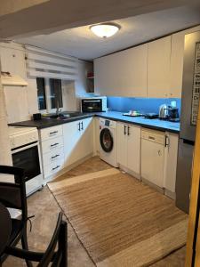 a kitchen with white cabinets and a dishwasher at Alfeios cozy stays - Rustic 