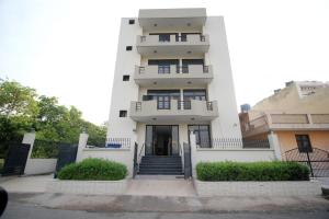 a tall white building with stairs in front of it at Hotel O Staysnap in Indirapuram
