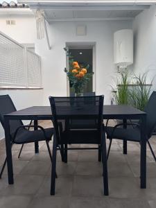 a black dining room table with a vase of flowers on it at Los Titos in Arriate +4 photos