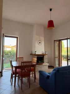 a living room with a table and chairs and a couch at La Maison D'Amì in Anguillara Sabazia