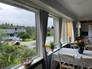 a dining room with a table and a large window at House under the Aurora Cozy Private Home with Fireplace in Laukvik