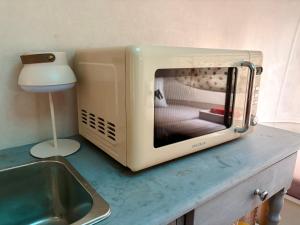 a microwave sitting on a counter next to a sink at Salève Glamping in Archamps