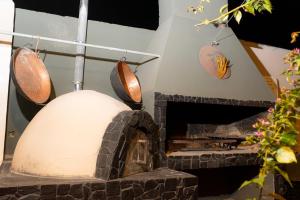 a stone oven with pots and pans on a wall at HOSTEL La Casa de Li - En in Chilecito