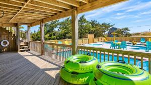 a deck with two inflatable tubes next to a swimming pool at Rio Rodanthe Lazy River Kiddie Pool Oceanfront Elevator in Rodanthe