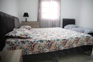 una camera da letto con un letto con piumone e cuscini di Babylon Gardens a Sousse