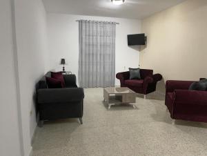 un soggiorno con due divani e una TV di Babylon Gardens a Sousse Altre 2 foto