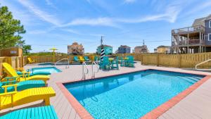 a pool with yellow and blue chairs in a yard at Rio Rodanthe Lazy River Kiddie Pool Oceanfront Elevator in Rodanthe +48 photos