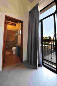 a bathroom with a toilet and a sliding glass door at Hotel Camino Del Bosque Centro Pádel in Cholula +31 photos