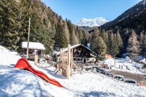 a ski lodge with a playground in the snow at Gîte du Prilet in Saint-Luc