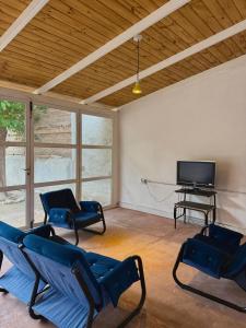 a living room with chairs and a television and a piano at Los Horneros in Santa María
