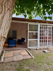 a patio with a sliding glass door and a chair at Los Horneros in Santa María