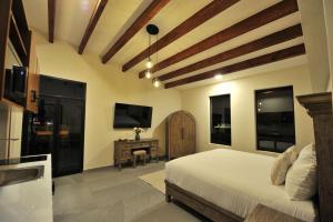 a bedroom with a bed and a television and a table at Hotel Camino Del Bosque Centro Pádel in Cholula