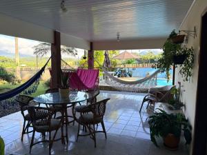 a patio with a table and chairs and a hammock at Paraíso Pomerode in Pomerode