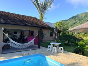 a villa with a hammock and a swimming pool at Paraíso Pomerode in Pomerode