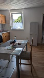 a kitchen with a table with a chair and a window at Waldesruh in Pirmasens