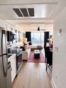 a kitchen and living room with a couch and a table at Boardwalk Noir - Oceanfront Studio Yachtsman 404 in Myrtle Beach