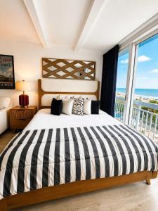a bedroom with a large bed with a view of the ocean at Boardwalk Noir - Oceanfront Studio Yachtsman 404 in Myrtle Beach
