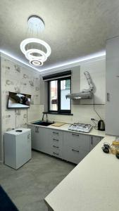 a large kitchen with white cabinets and a window at 10 USD New Hotel in Tashkent