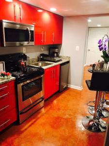cocina con armarios rojos y estufa negra en Studio H St Corridor, en Washington