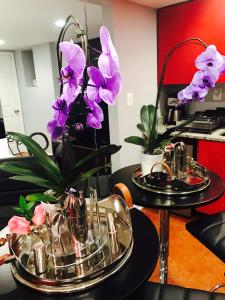 two tables with glass plates and purple flowers on them at Studio H St Corridor in Washington