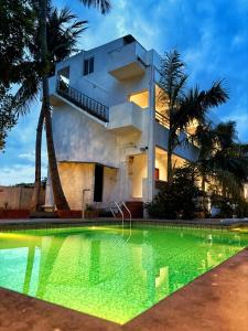 a house with a swimming pool in front of a building at Dreamy serenity beach side in Pondicherry