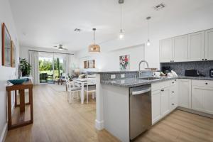 a kitchen with white cabinets and a dining room at Fairway Villas Waikoloa by OUTRIGGER in Waikoloa