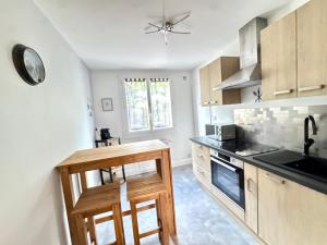 a kitchen with a sink and a stove top oven at Le petit sauna de Sarah in Voiron