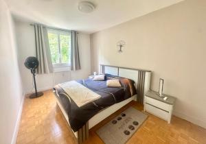 a bedroom with a bed and a window at Le petit sauna de Sarah in Voiron
