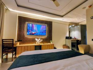 a bedroom with a bed and a tv on the wall at Cozyco Stays in Nalmatha +2 photos