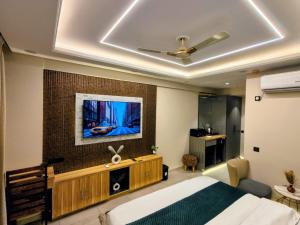 a bedroom with a bed and a tv on a wall at Cozyco Stays in Nalmatha