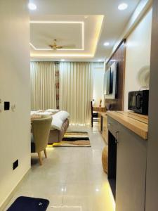 a room with a bed and a kitchen with a microwave at Cozyco Stays in Nalmatha