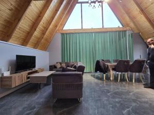 a living room with chairs and a tv and a table at Villa ZM garden in Quba