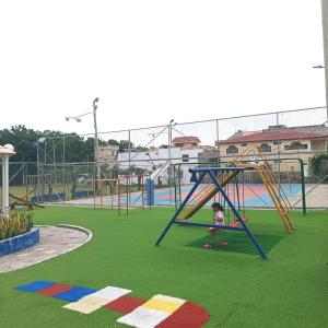 a child playing on a swing set in a playground at Departamento en Manta amoblado con seguridad privada in Manta